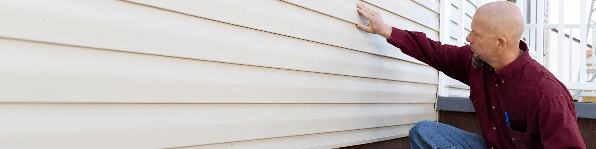 Contractor inspecting siding