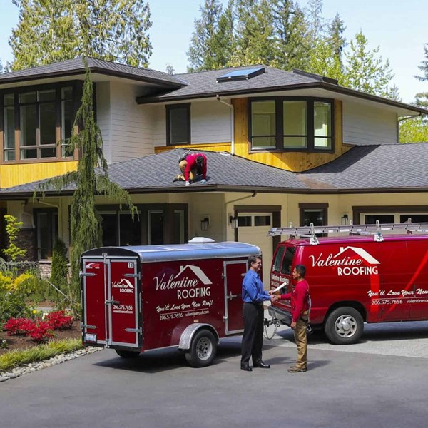 Roofing crew performing final walk through with happy customer and performing final clean up on job site after new roof shingle installation