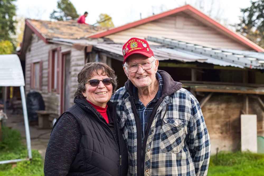 Floyd and his wife standing in front of their newly renovated home 