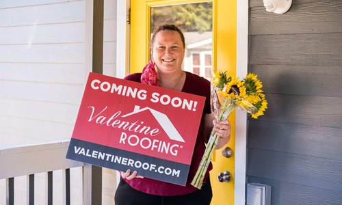 gabby holding a Valentine Roof coming soon sign 