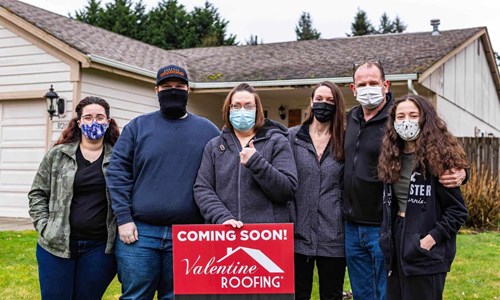 Holly and her family in front of her house with a new roof