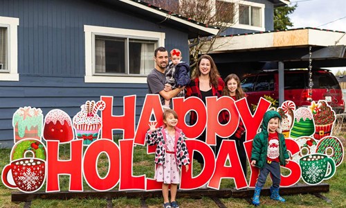 The Mnieriem Family Standing outside their home with a new roof